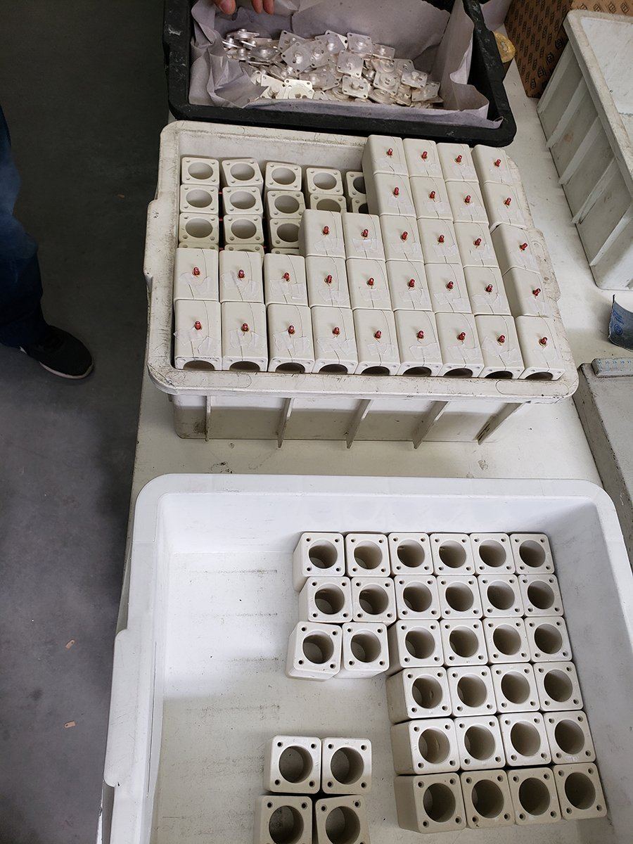 Trays of unfilled ceramic fuse bodies at the assembly bench