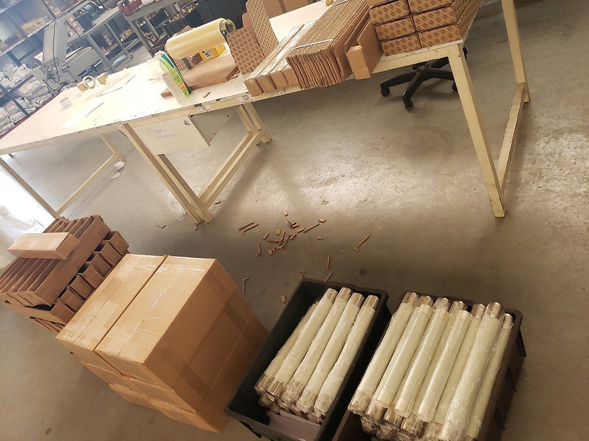 Ceramic fuse bodies laid out on wooden racks on the plant floor